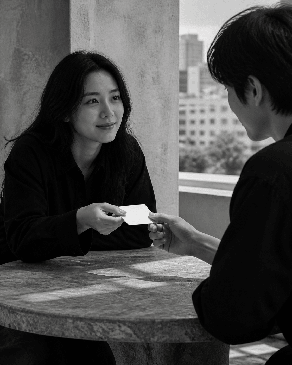 야외 테이블에서 제안 카드를 건네며 대화하는 성인 두 명